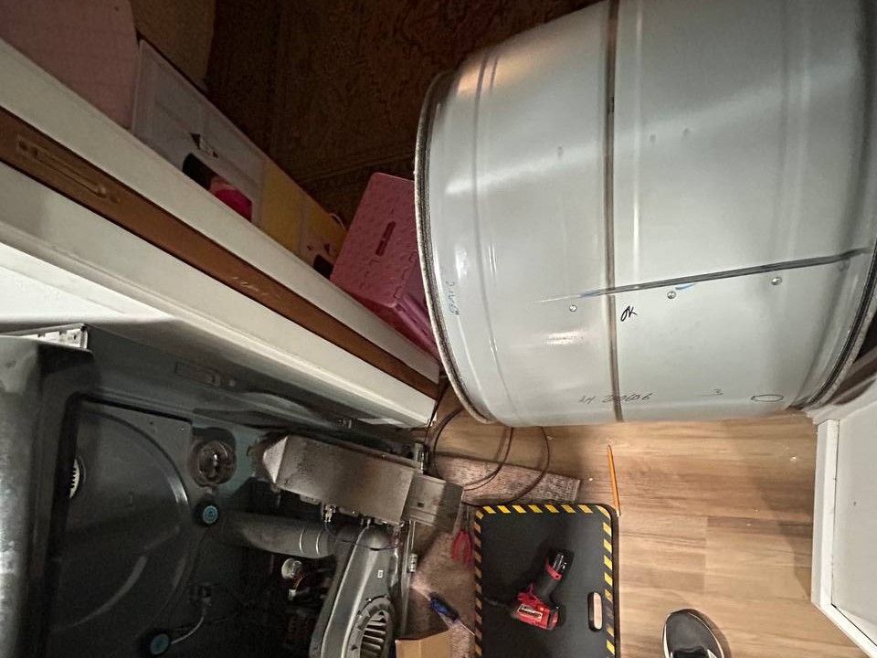 Dryer cabinet opened with the drum removed, showing the blower housing and motor