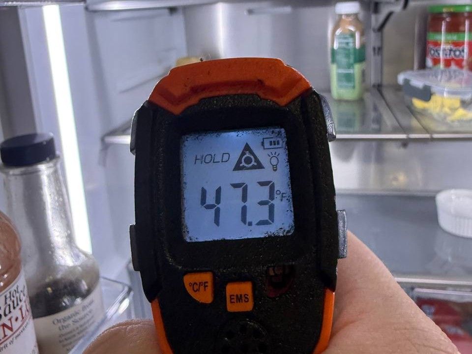 Infrared thermometer reading 47 °F inside a refrigerator during a diagnostic